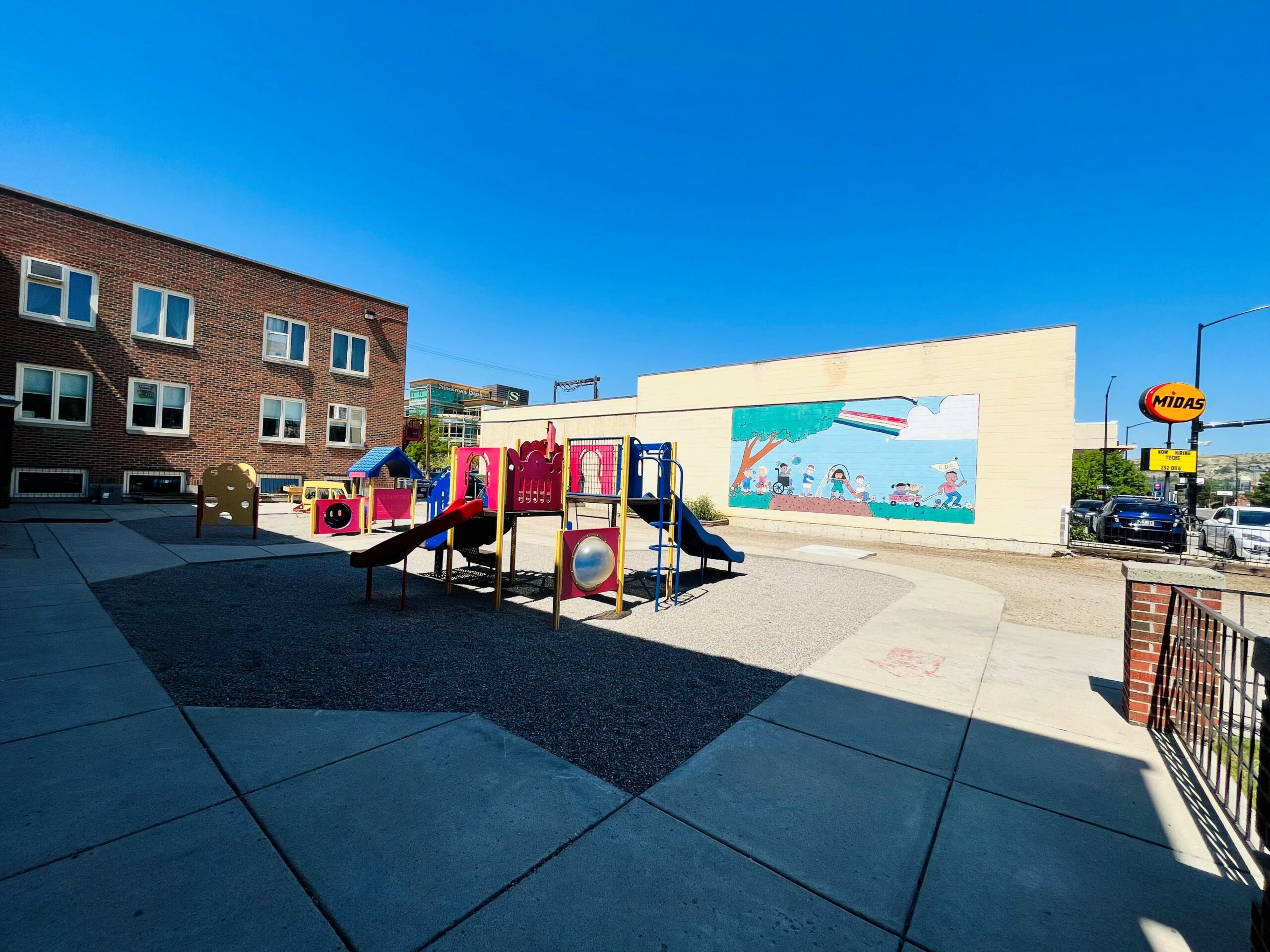 The Billings First Congressional Church courtyard with the old mural of primary colors and kids playing.