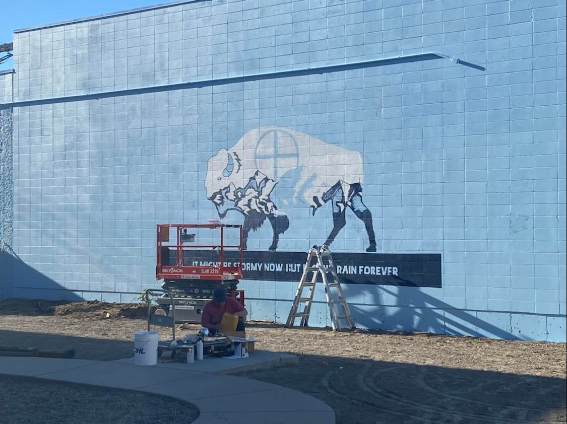Progress photo of new 40 foot Bison mural on the blue wall. 